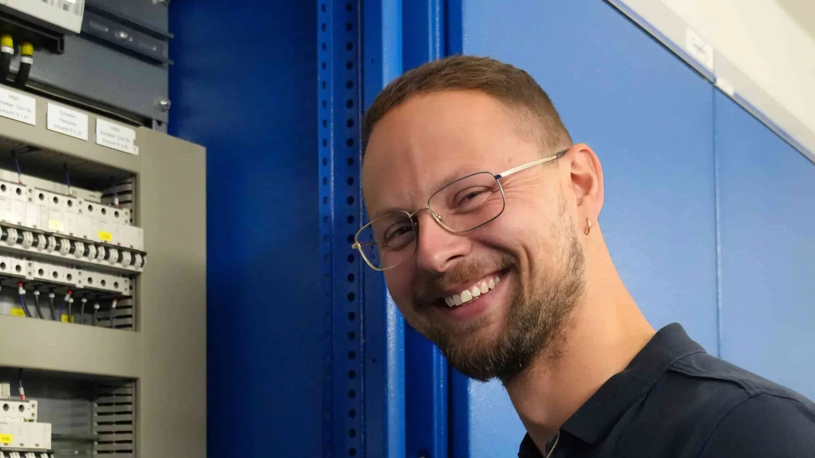 Elektrotechniker vor einem geöffneten Schaltschrank