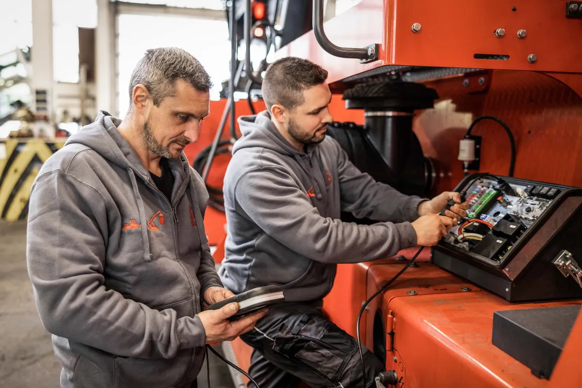 Zwei Servicetechniker lesen mit einem Tablet die Diagnosedaten einer Maschine aus
